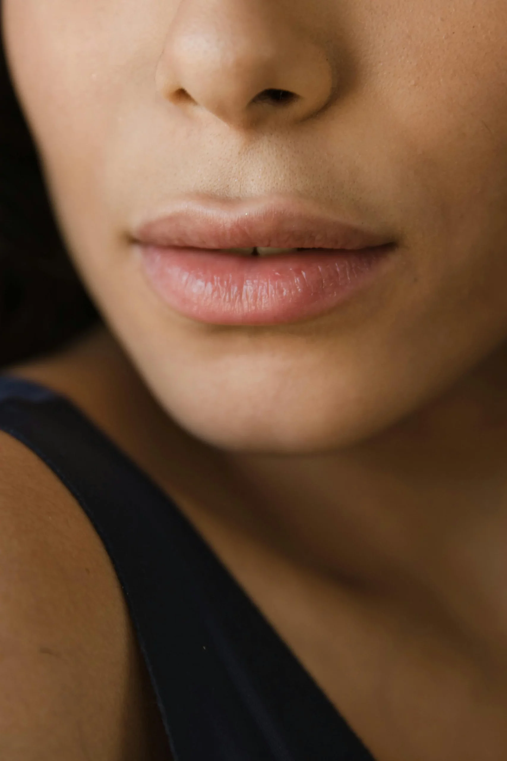 Volle Lippen ohne Lippenstift in einem schmalen Frauengesicht